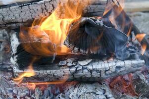 un cerca arriba de un fuego con madera y carbón foto