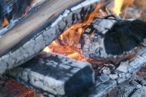 un cerca arriba de un fuego con madera y carbón foto