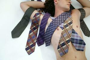 a man laying on his back with several ties on his chest photo