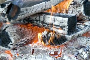 un cerca arriba de un fuego con madera y carbón foto