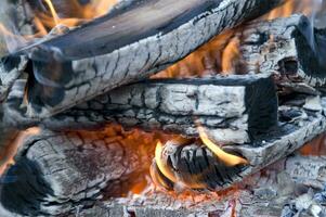 un cerca arriba de un fuego con madera y carbón foto