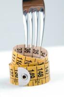 a fork and knife surrounded by measuring tape photo