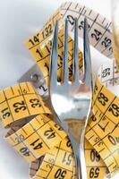 a fork and knife surrounded by measuring tape photo