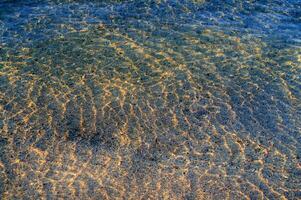 the water is clear and blue with sand photo