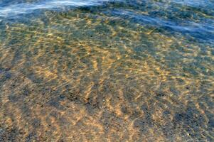 el agua es claro y azul con arena foto