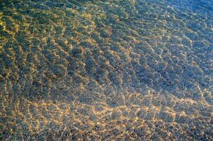 the water is clear and blue with sand photo