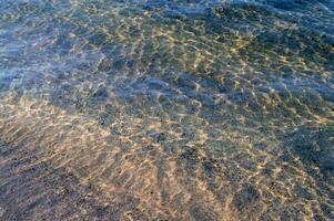 el agua es claro y azul con arena foto