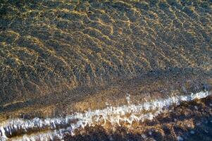 el agua es claro y azul con arena foto