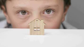 a boy looking at a wooden house with a window video