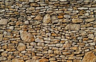 a stone wall with many different types of rocks photo