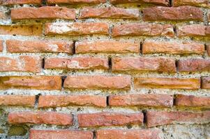 un antiguo ladrillo pared con un agujero en eso foto