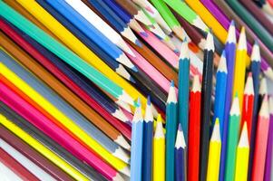 many colored pencils are arranged in a row photo