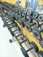 un fila de pesas en un estante en un gimnasio foto