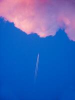 a jet plane flying through a cloudy sky photo