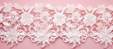 A close-up photograph of a beautiful white lace cloth on a pink background. detailed floral pattern photo