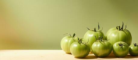 verde Tomates puesto fuera en brillante luz de sol en un beige antecedentes con espacio para texto foto