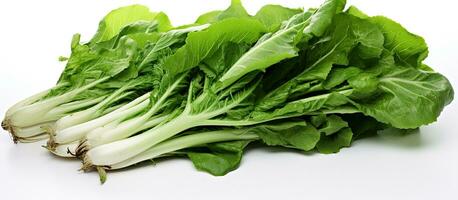 Ready to be cooked, fresh chicory greens are placed on a white table. There is copy space available photo