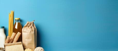 A blue background with copy space featuring a paper bag containing essential food items such photo