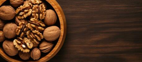 Walnut halves, arranged in a wooden bowl, are captured in a close-up view from above against photo