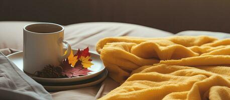 This autumn-themed composition features yellow and burgundy blankets, a cup of coffee, red and photo