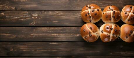 Traditional Easter Hot Cross Buns photographed from above on a wooden background, with copy photo