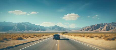 A vehicle embarks on a road trip adventure through a desert on a hot summer morning. It drives photo