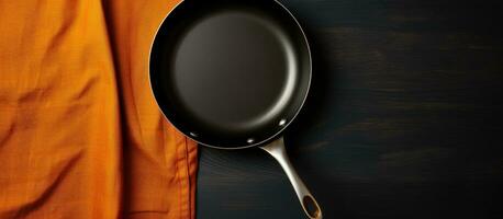 Top view of an empty frying pan and napkin on a black background, with copy space available photo