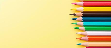 Top view of colored pencils on a light yellow background. Copy space and space for text. photo