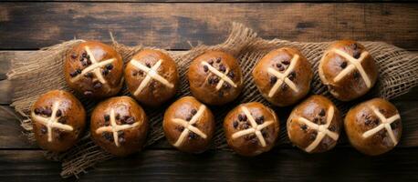 Traditional Easter Hot Cross Buns photographed from above on a wooden background, with copy photo