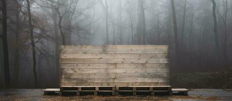 wooden pallet leaning against the wall of a warehouse in a field, next to a forest, on a rainy photo