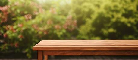 A wooden table with no objects on it and a blurred background of an outdoor garden. It provides photo