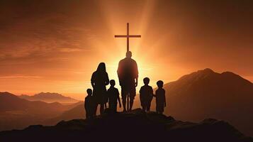 Christian family holding cross praying on mountain at sunset Easter Sunday concept photo
