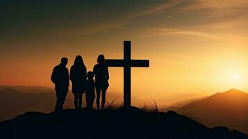 Christian family holding cross praying on mountain at sunset Easter Sunday concept photo