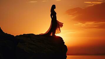 Person standing on rock gazing at sunset photo