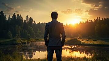 Businessman in nature at sunrise representing success and new opportunities photo