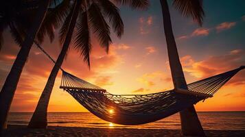 Tranquil tropical beach with palm trees and hammock silhouette at sunset representing carefree summer enjoyment and positive energy photo