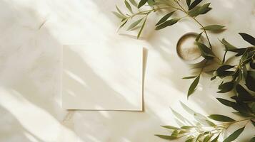 Summer wedding stationery mock up scene with a blank greeting card wooden plate and olive tree leaves and branches in sunlight White table background with palm shadows Femi photo