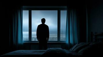 solitario hombre miradas a cerrar ventana en dormitorio foto