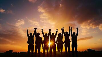 Group of business team members raising hands in the sunset sky background to depict teamwork photo