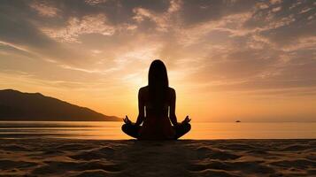 Woman practicing mantra yoga meditation outdoors on the beach at sunset achieving peaceful relaxation and spiritual well being photo