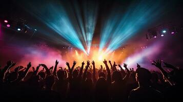 Cheering crowd illuminated by vibrant stage lights at concert photo