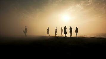 Silhouetted individuals on the beach during summer fog photo
