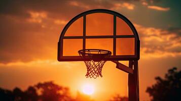 Ideal wallpaper with silhouette of setting sun in basketball hoop photo