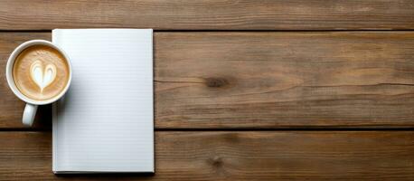 Notebook seen from above with coffee and light on wooden table photo