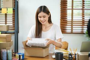 Business From Home Asian woman preparing package delivery box Shipping for shopping online. young start up small business owner at home online order photo