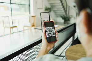 Qr code payment. E wallet. Man scanning tag accepted generate digital pay without money.scanning QR code online shopping cashless payment and verification technology concept photo