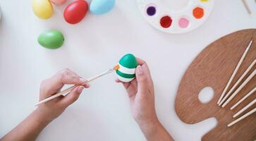 Woman painting Easter eggs at home. family preparing for Easter. Hands of a girl with a easter egg photo