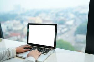 Woman Working by using laptop blank screen computer . Hands typing on a keyboard.technology e-commerce concept. photo