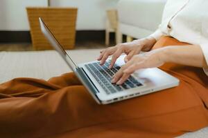 Working by using a laptop computer on wooden table. Hands typing on a keyboard.technology e-commerce concept photo