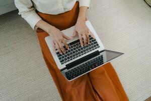 Working by using a laptop computer on wooden table. Hands typing on a keyboard.technology e-commerce concept photo